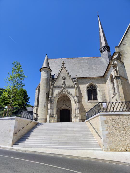 Église en pierre avec escalier et barreaudage en ferronnerie