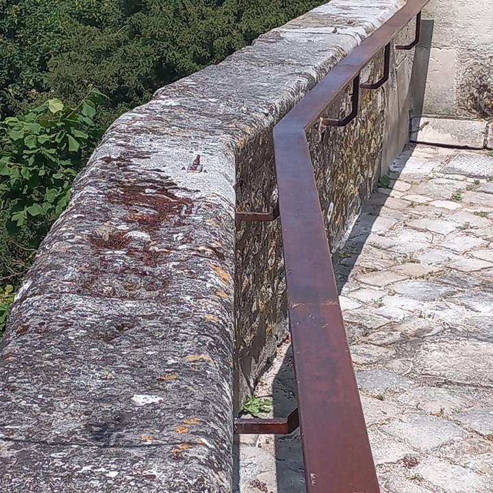 Garde-corps en acier vieilli fixé sur une corniche en pierre d'église
