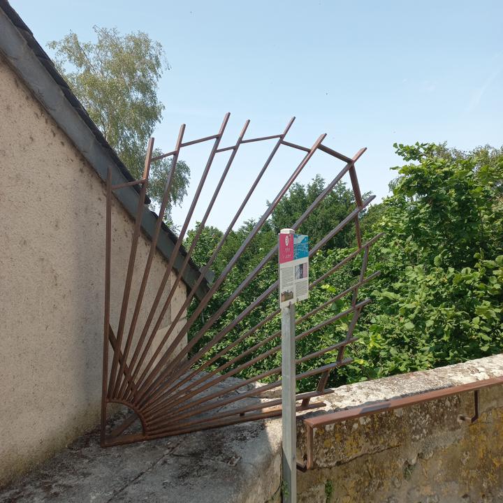 Grille en éventail en fer forgé posée en haut d'un mur d'église