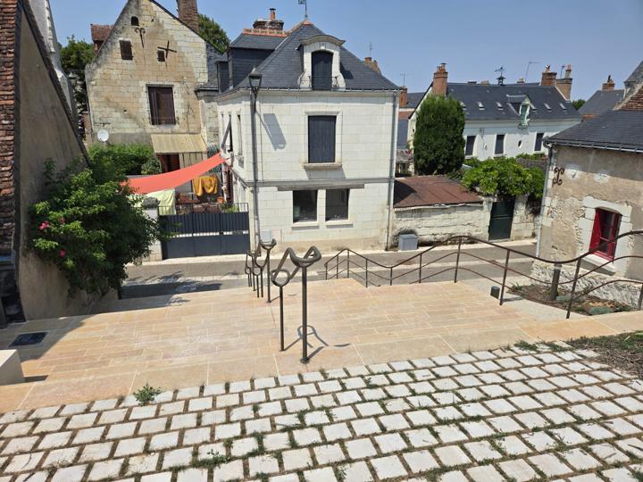 Mains courantes métalliques aux extrémités recourbées sur un escalier en pierre dans le bourg de Véretz