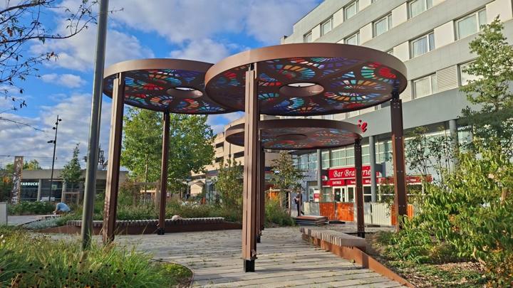 Trois ombrières circulaires en acier aux motifs découpés colorés sur le parvis de la gare de Saint-Pierre-des-Corps
