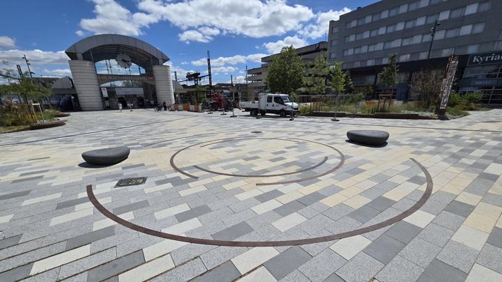 Point de convergence et cercles en acier corten incrustés dans le dallage du parvis, devant la gare de Saint-Pierre-des-Corps